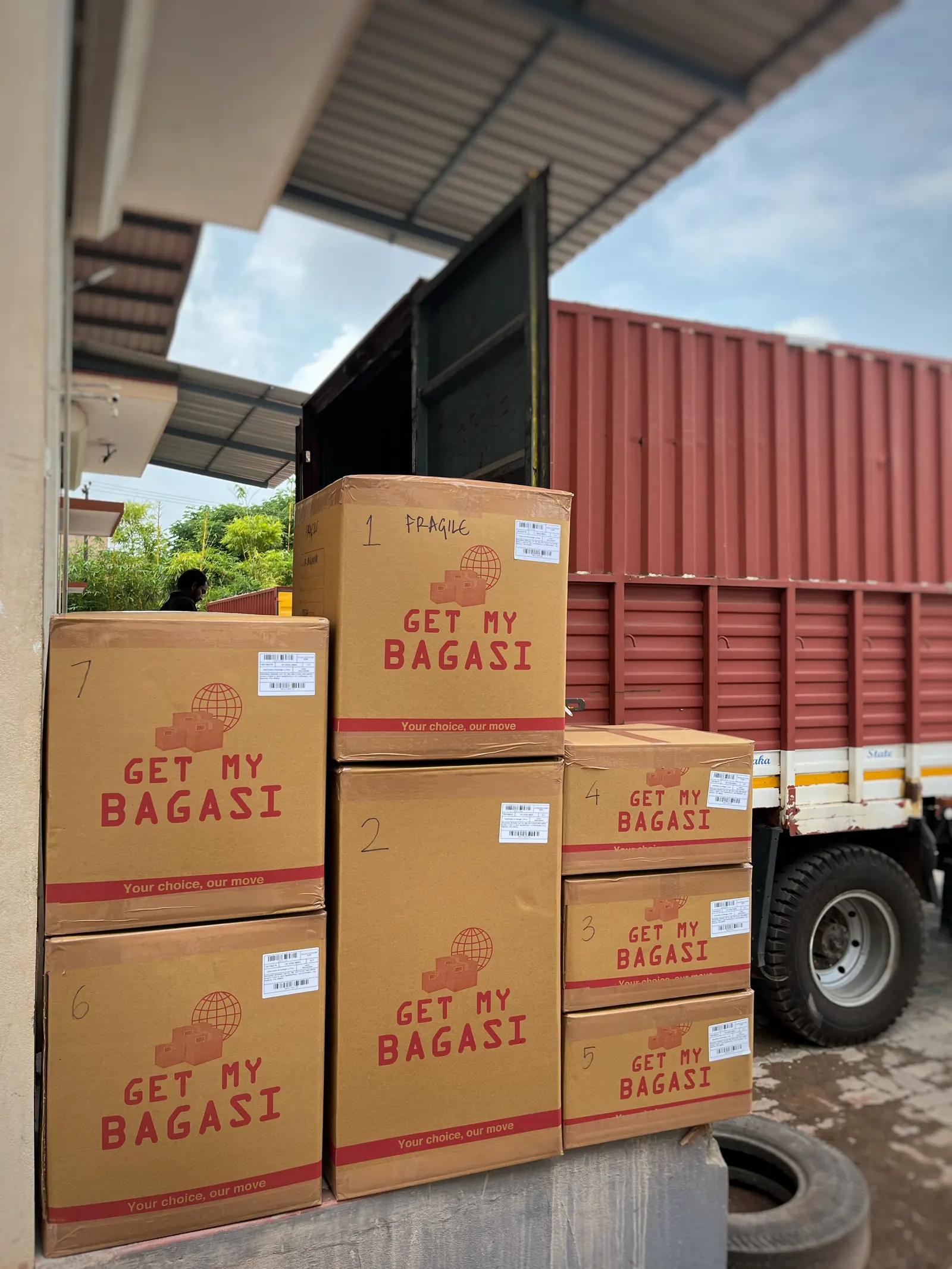Numbered Get My Bag cartons stacked in front of a truck on loading day