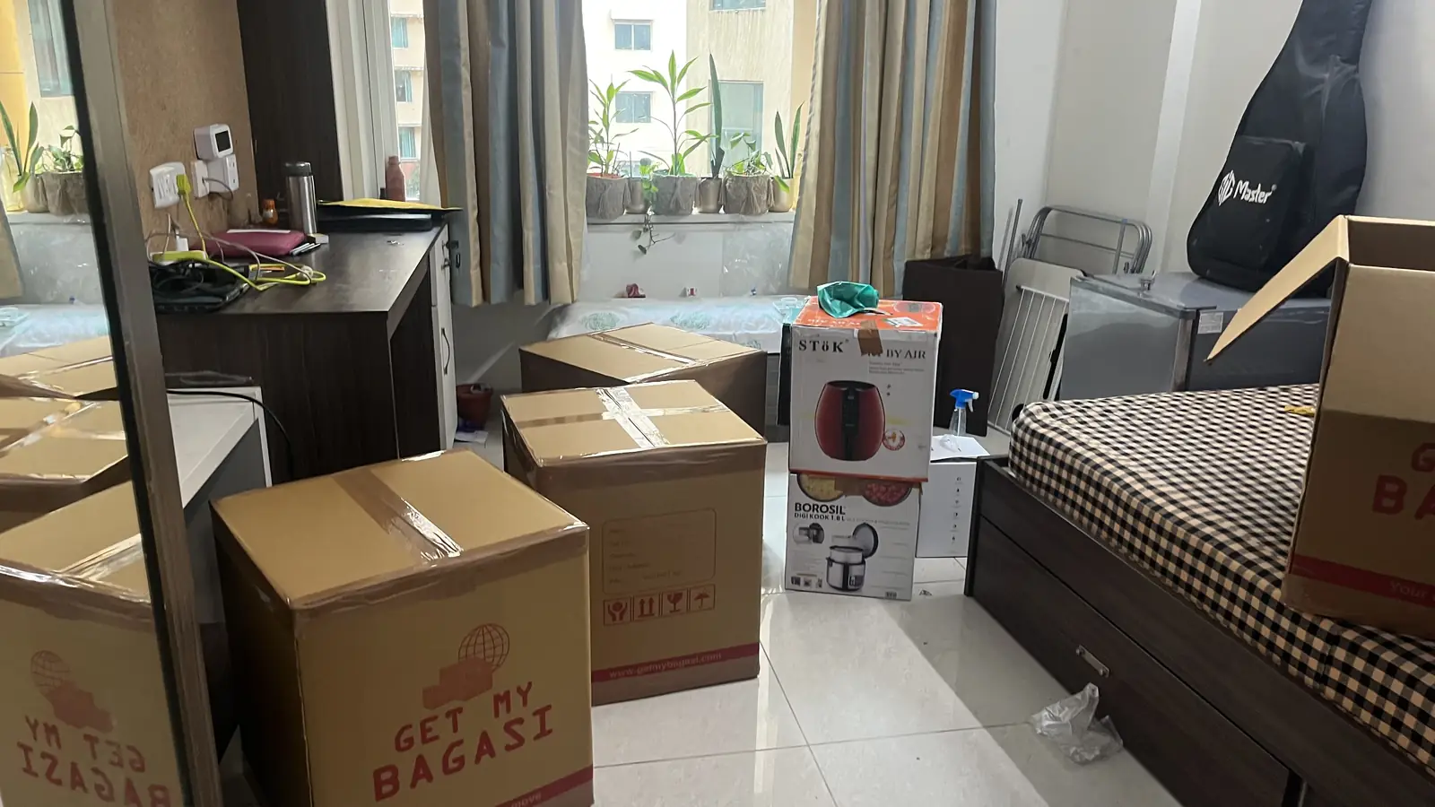 Packed and labelled Get My Bag cartons in a student's room, ready for pickup